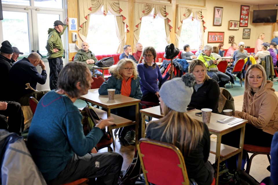 a group of people are sitting at tables in a restaurant