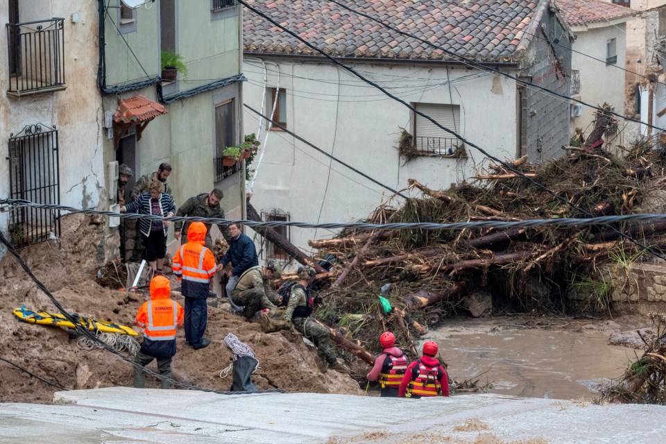 Soldiers and emergency services rescue people trapped in their homes after floods in Albacete