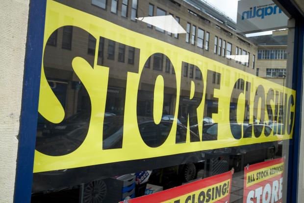 a store with a yellow sign that says store closing