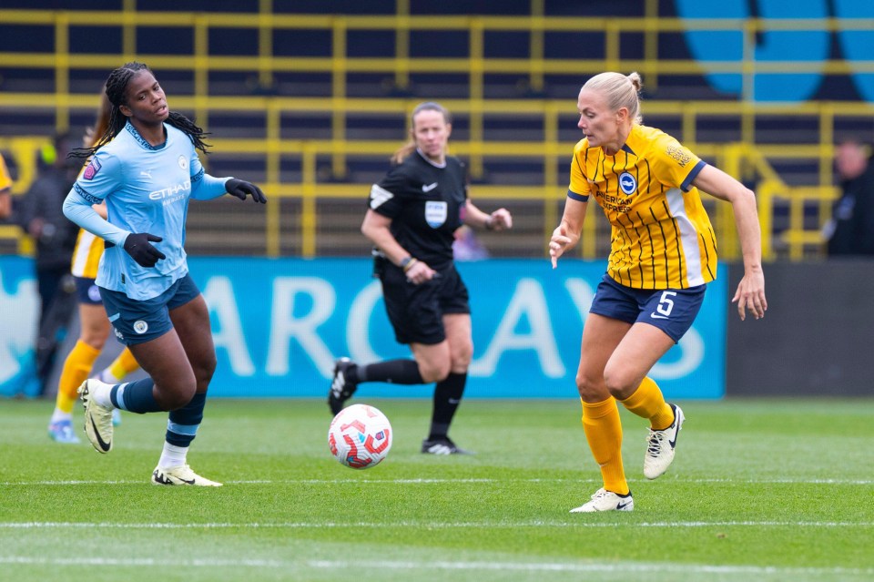 two female soccer players on a field with one wearing a jersey that says american express