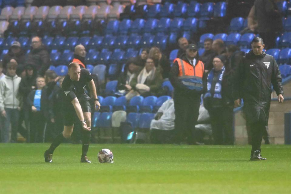 a referee kicks a soccer ball on a field