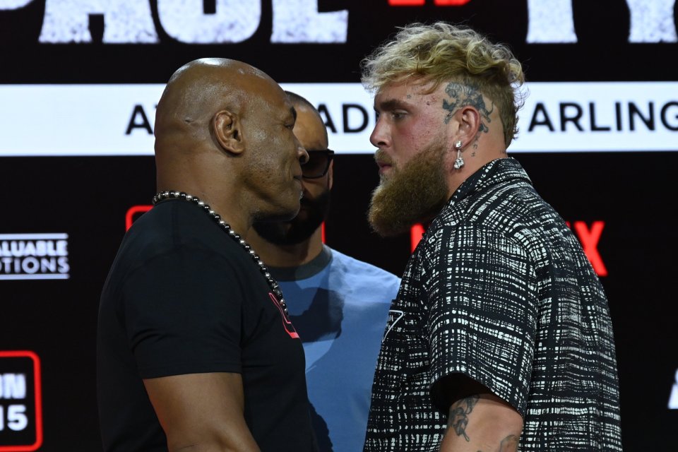 two men face to face in front of a sign that says paul