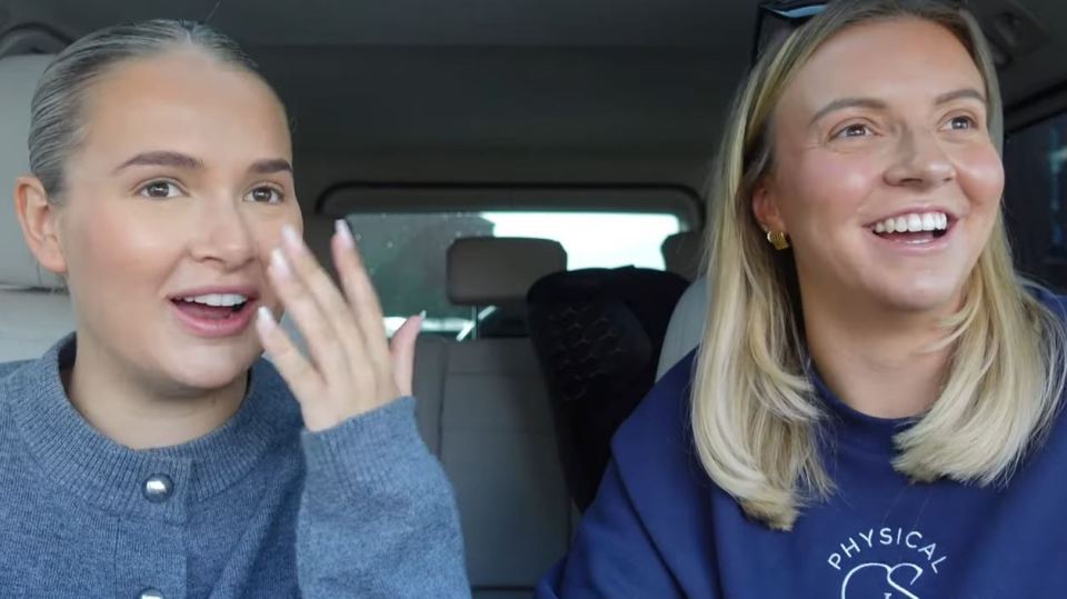 two women in a car one wearing a physical sweatshirt