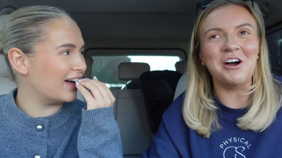 two women in a car one wearing a physical sweatshirt