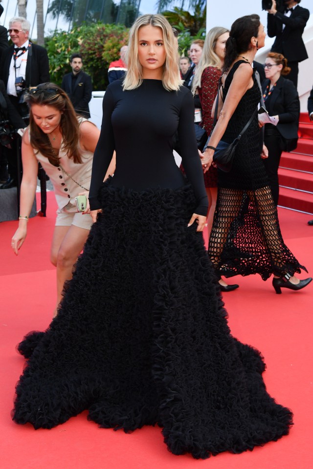 a woman in a black dress with ruffles on the skirt