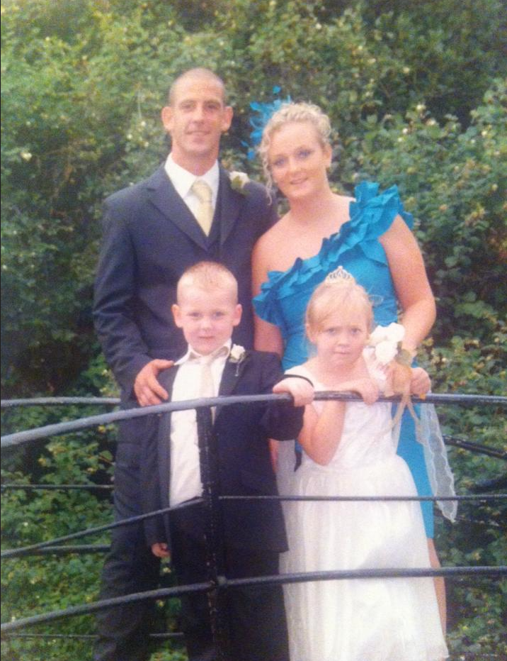 a bride and groom pose for a picture with their children