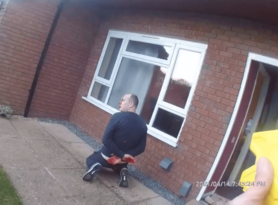 a man kneeling in front of a brick building with a time stamp of 2021/04/14