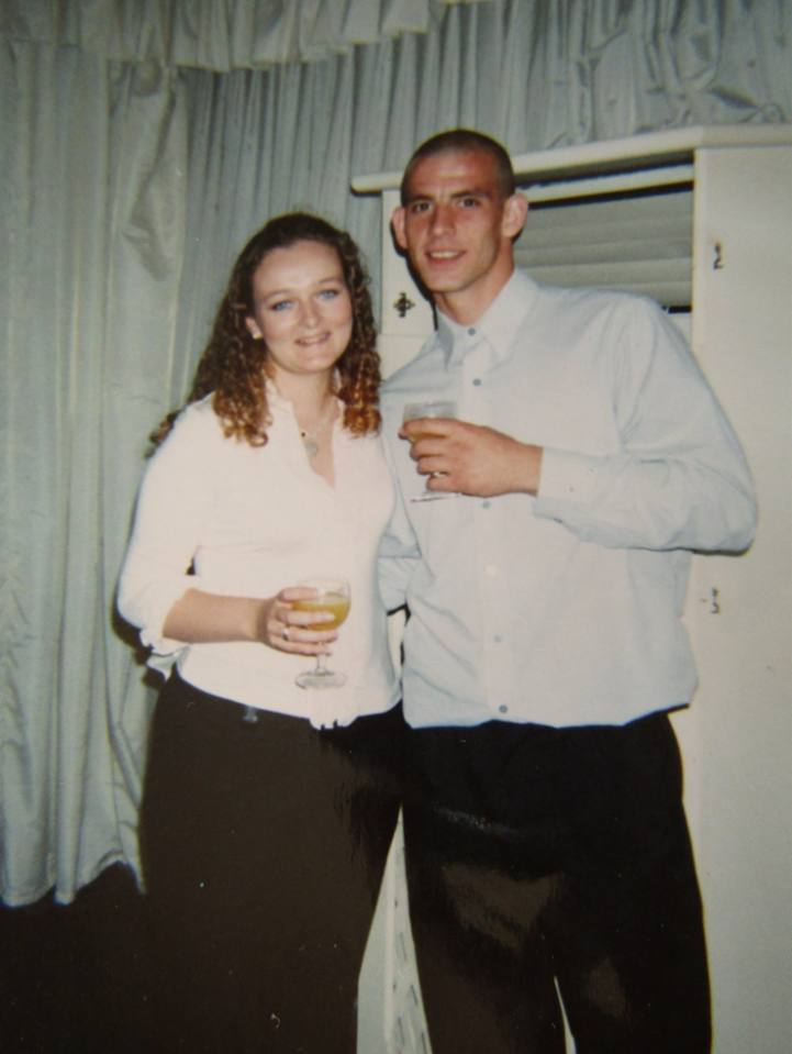 a man and a woman are posing for a picture in a kitchen with a coca cola can on the counter