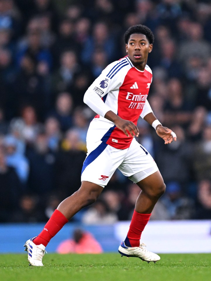 a soccer player wearing a red and white jersey that says emirates fly better