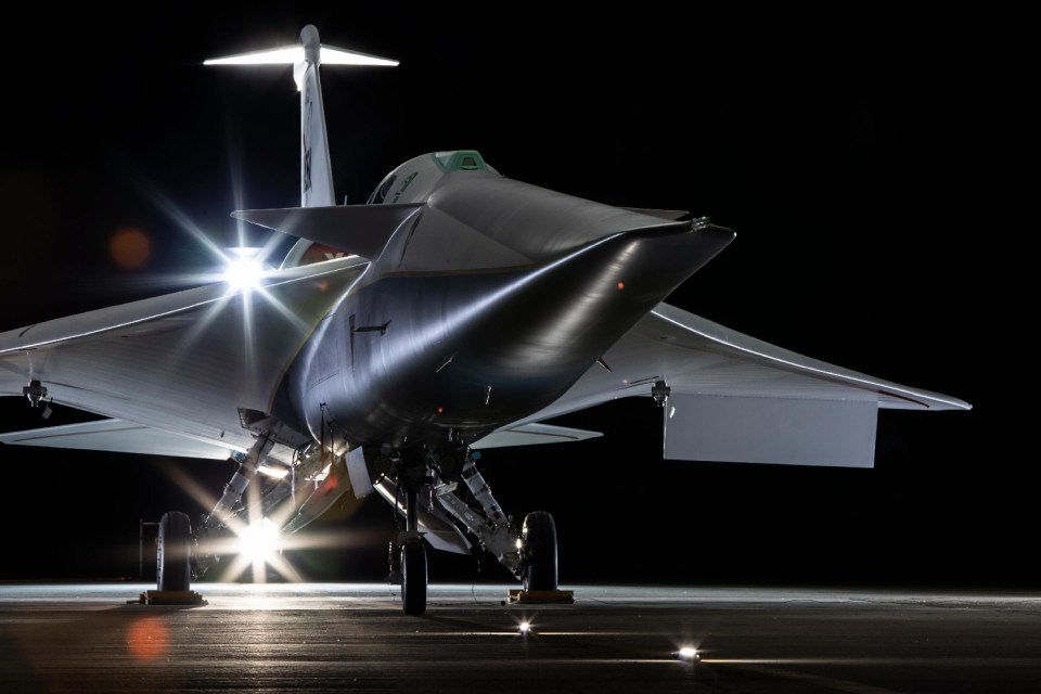 a fighter jet is parked on a runway at night