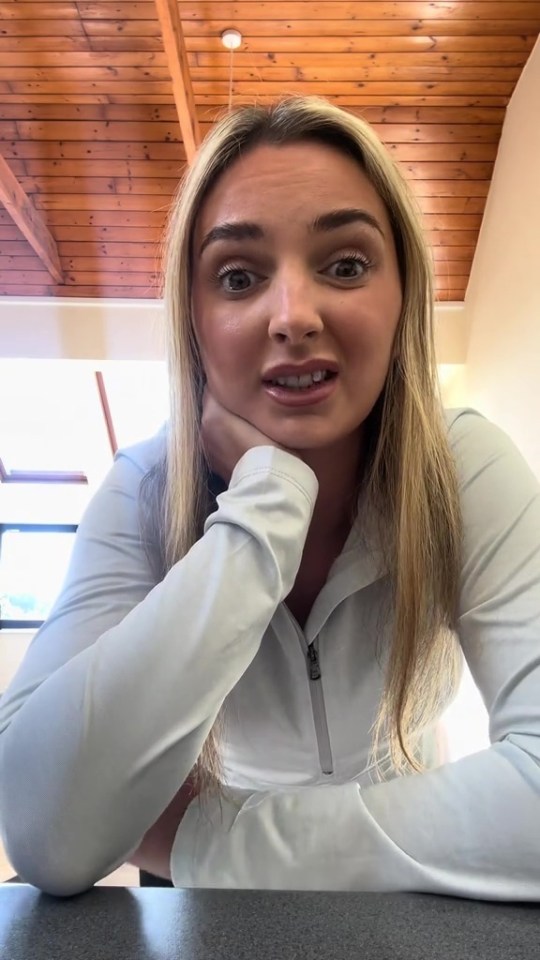 a woman sitting at a table with her hand on her chin