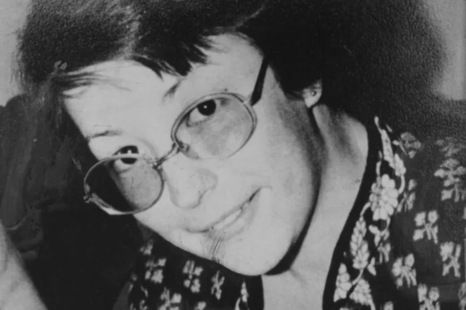 a black and white photo of a woman wearing glasses