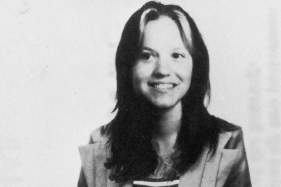 a black and white photo of a smiling woman with long hair