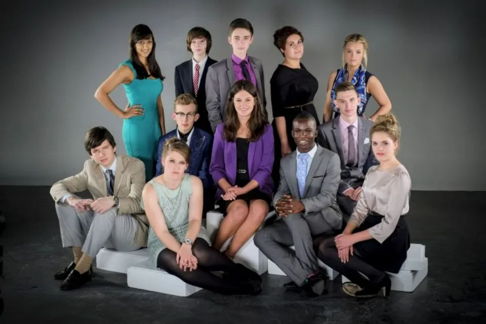 a group of people posing for a picture with one woman wearing a purple jacket