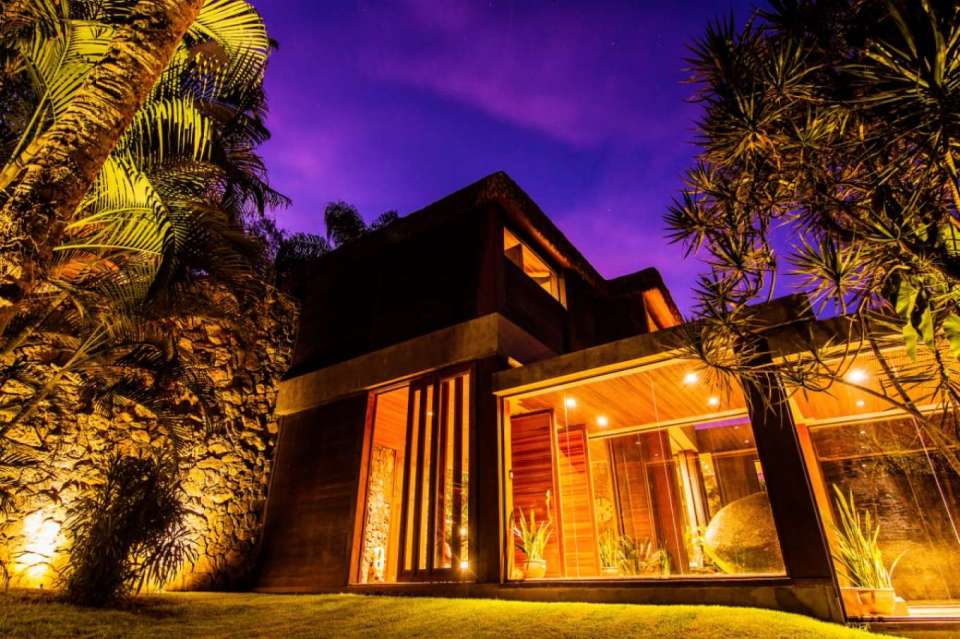 a house with a lot of windows is lit up at night