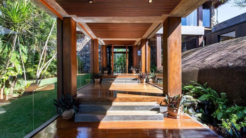 a long wooden hallway leading to a house