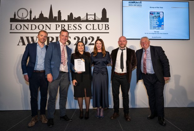 a group of people standing in front of a london press club sign