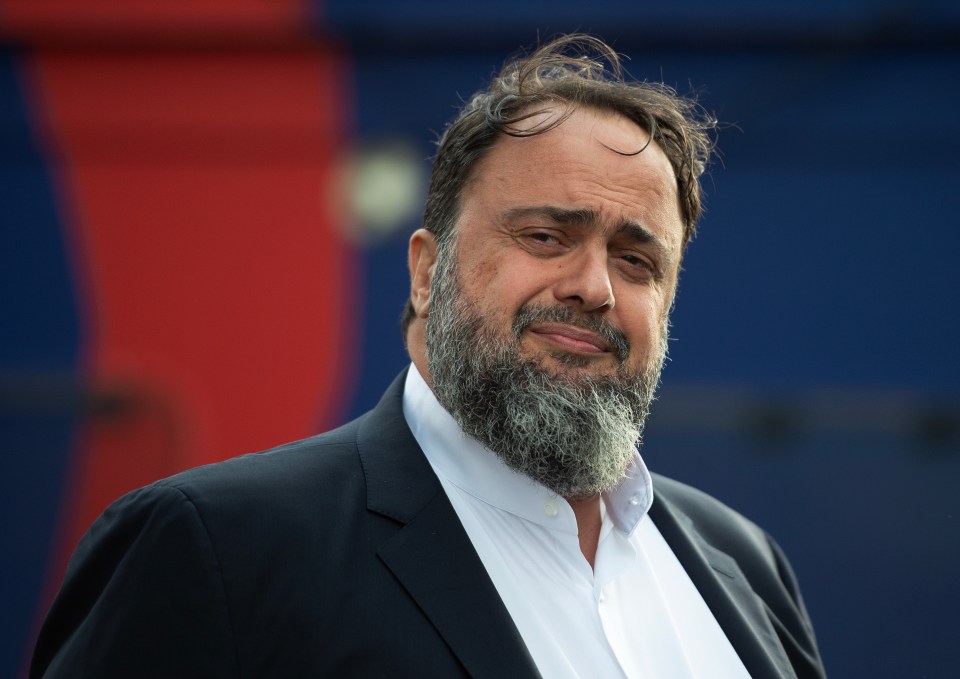 a man with a beard is wearing a suit and white shirt