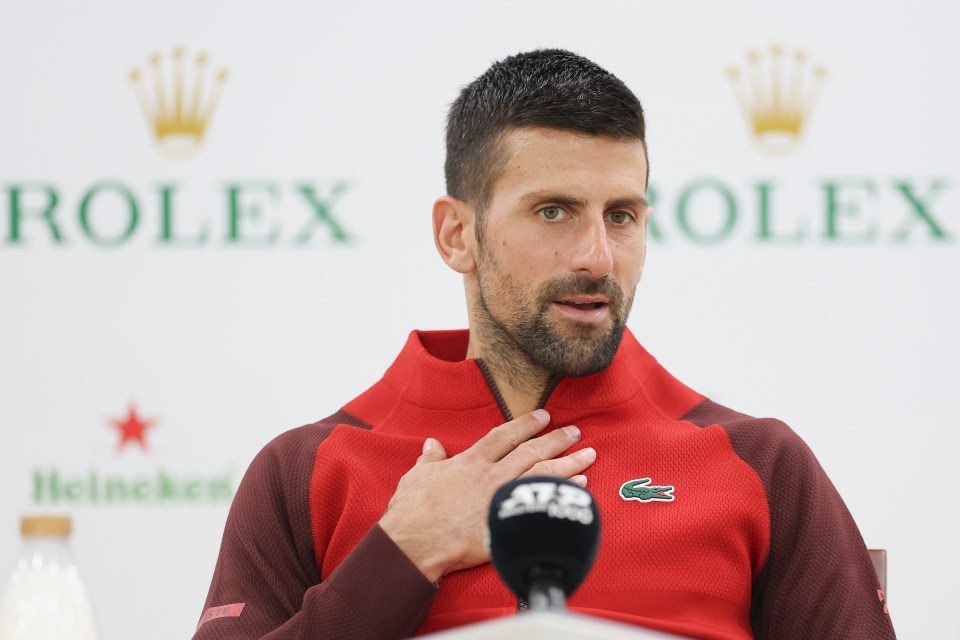 a man stands in front of a rolex sign