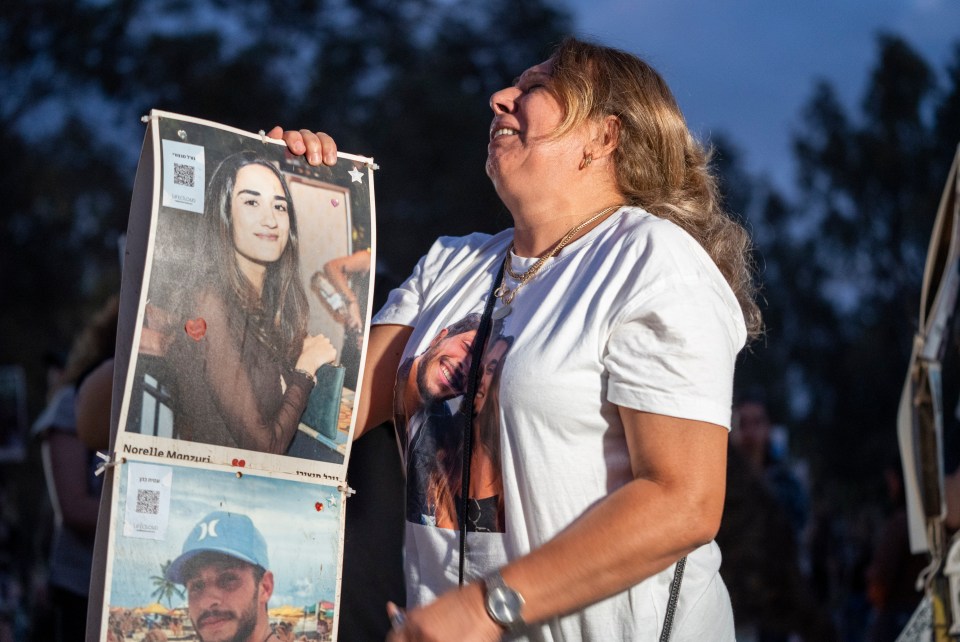 A woman sobs as she holds the photos of two victims