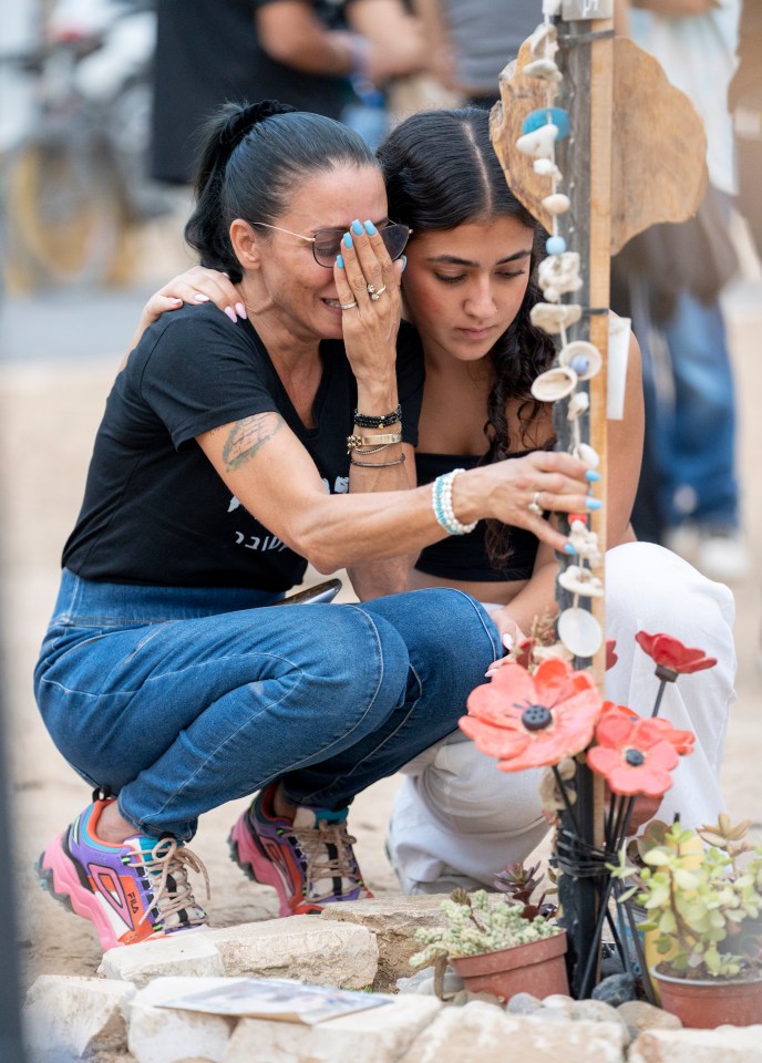 Two women comfort each other at the scene