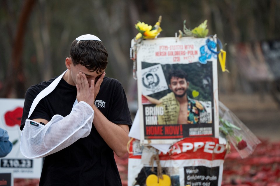 A man holds his head in his hands at the vigil