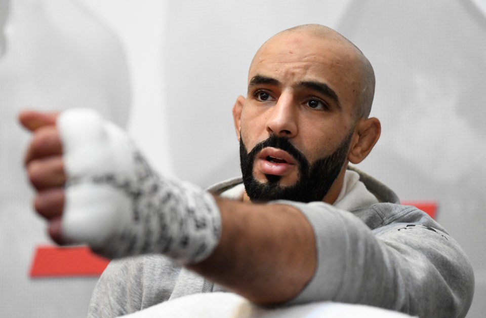 a bald man with a beard is wearing boxing gloves