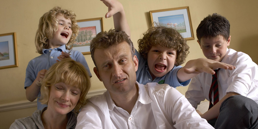 a family posing for a picture with a man making a funny face