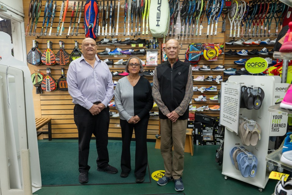 a man and two women stand in front of a head tennis bag