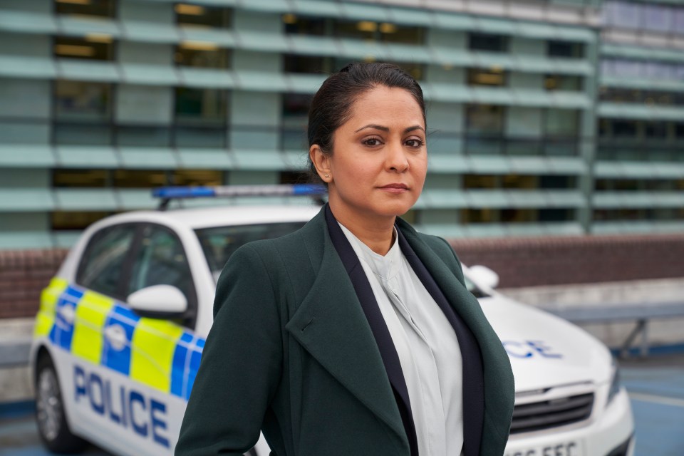 a woman stands in front of a police car