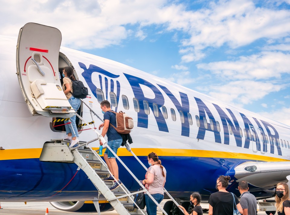 passengers boarding a ryanair plane wearing face masks