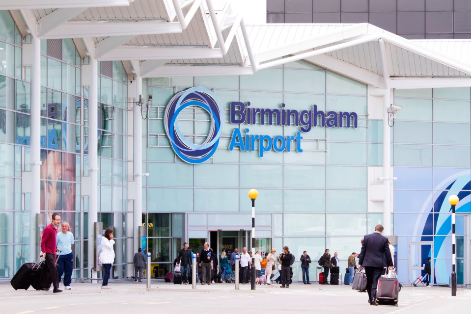 people walking in front of a building that says birmingham airport