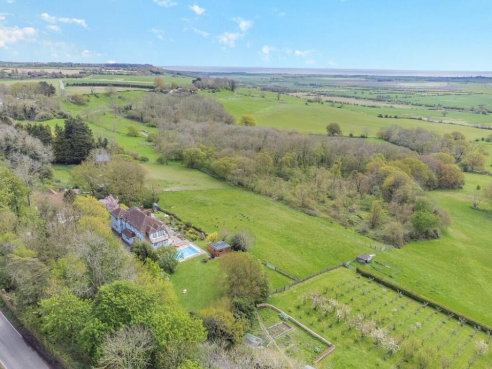 The house is surrounded by woodland