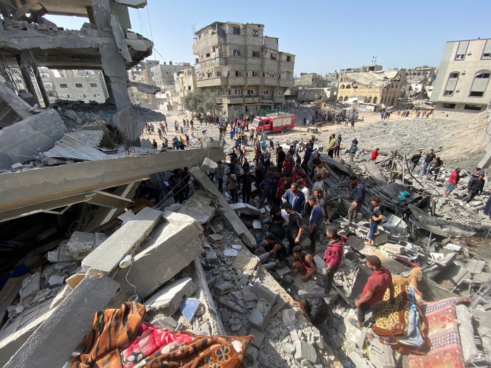 People work to recover Palestinian casualties from the rubble of a house following an Israeli strike in Gaza on Saturday