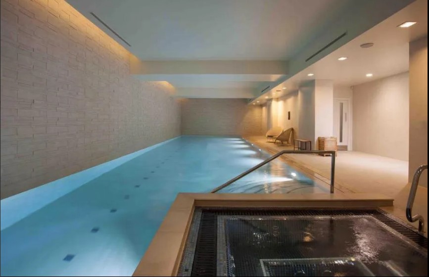 a large indoor swimming pool with a hot tub next to it