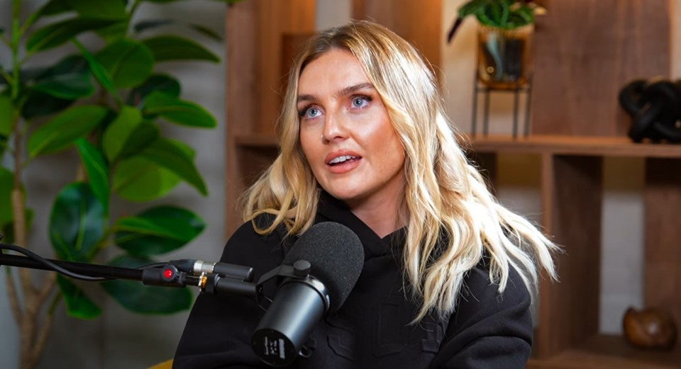 a woman in a black hoodie is talking into a microphone