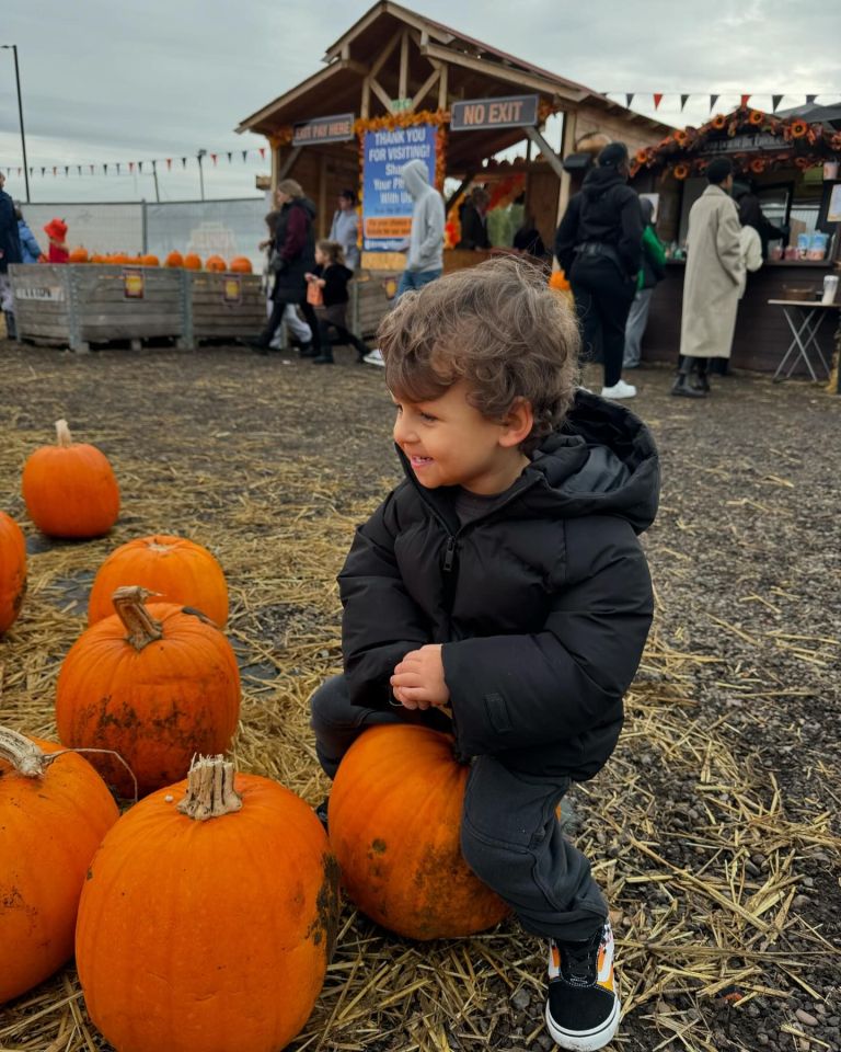 a little boy sits on a pumpkin in front of a no exit sign