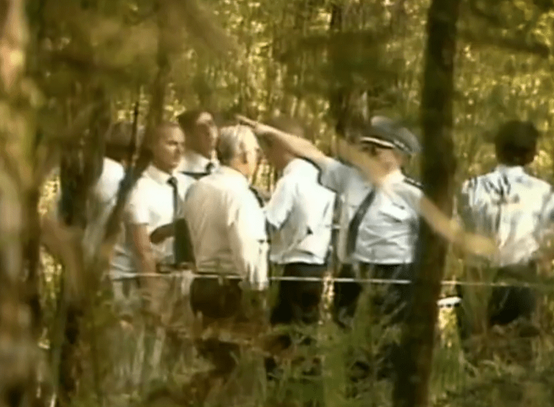 Cops at the scene where bodies of victims were found, weeks after they were snatched