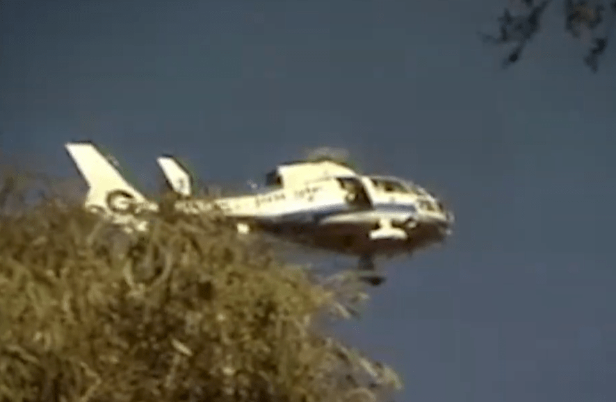 A police helicopter searches an area where remains of the victims were found