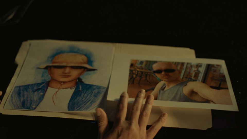 a person is holding a folder with pictures of a man wearing a hat and sunglasses