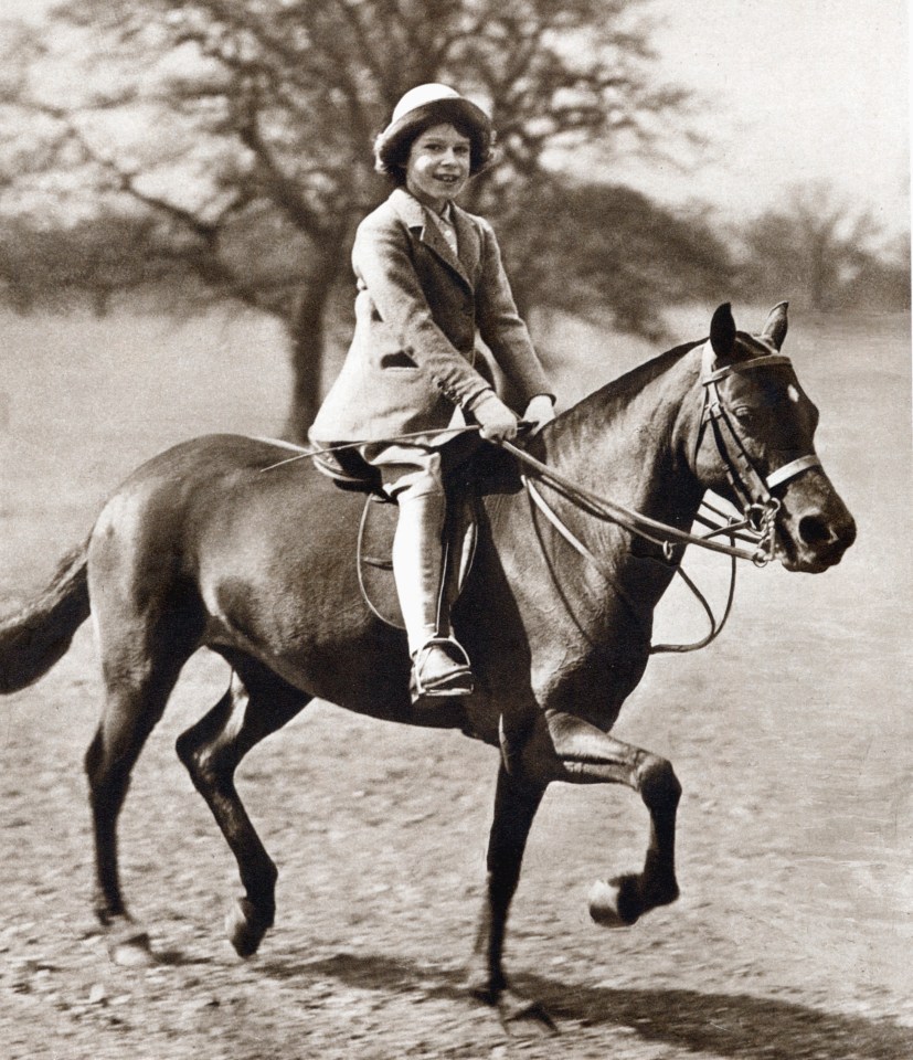 a black and white photo of a young girl riding a horse