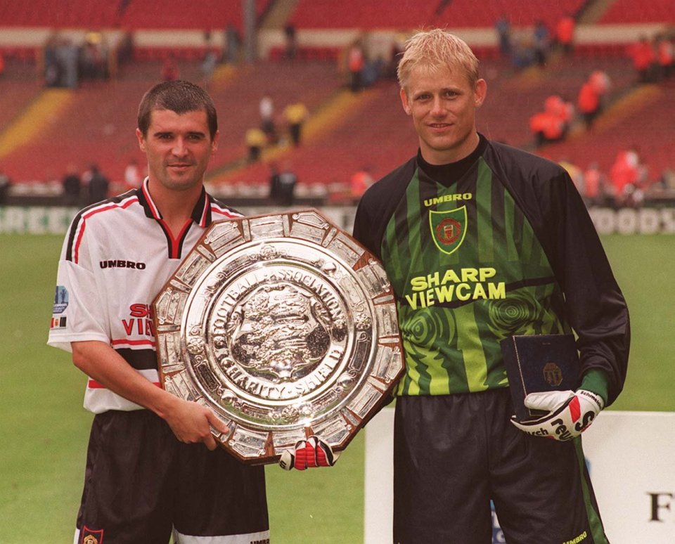 two soccer players holding a trophy with one wearing a shirt that says sharp viewcam