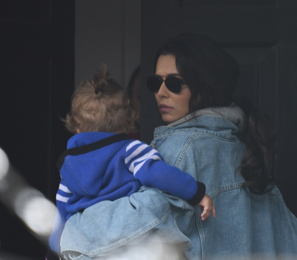 a woman in a denim jacket is holding a small child