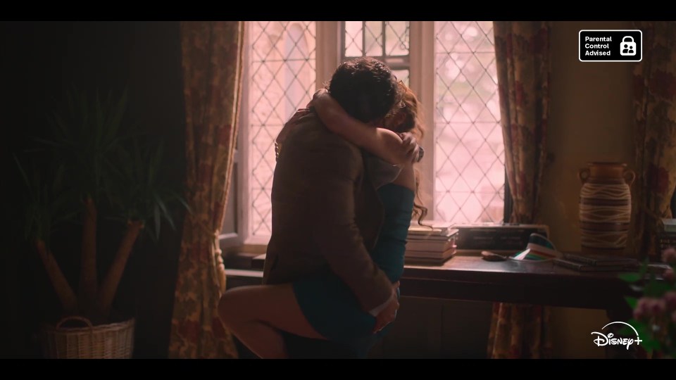 a man and woman hugging in front of a window with a parental advisory sign above them