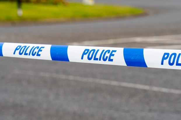 a blue and white police tape along the side of a road