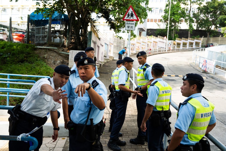 a group of police officers standing in front of a school sign