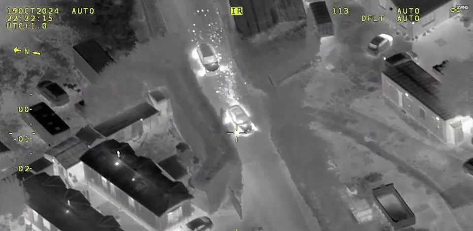 an aerial view of a car driving down a street at night