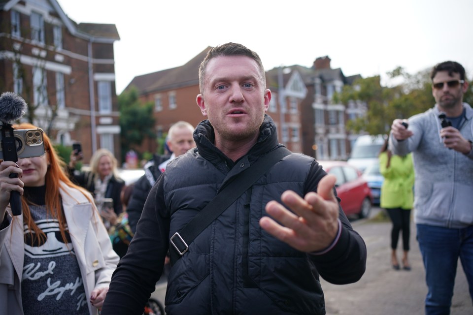 a man in a black vest is talking to a group of people