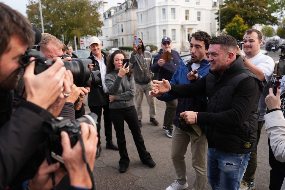 a man in a stone island jacket is being photographed by a group of people