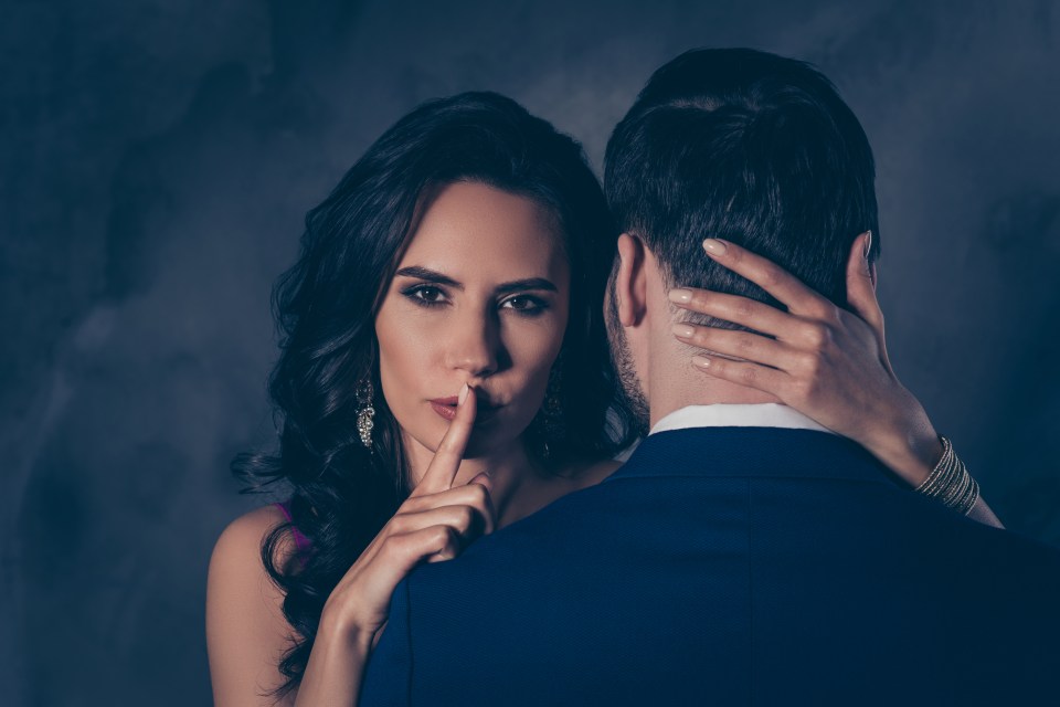 Woman whispering a secret to a man.